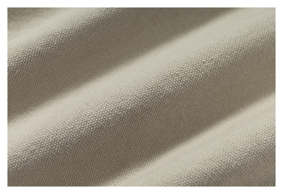 Macro view of the beige garment's textured woven surface.