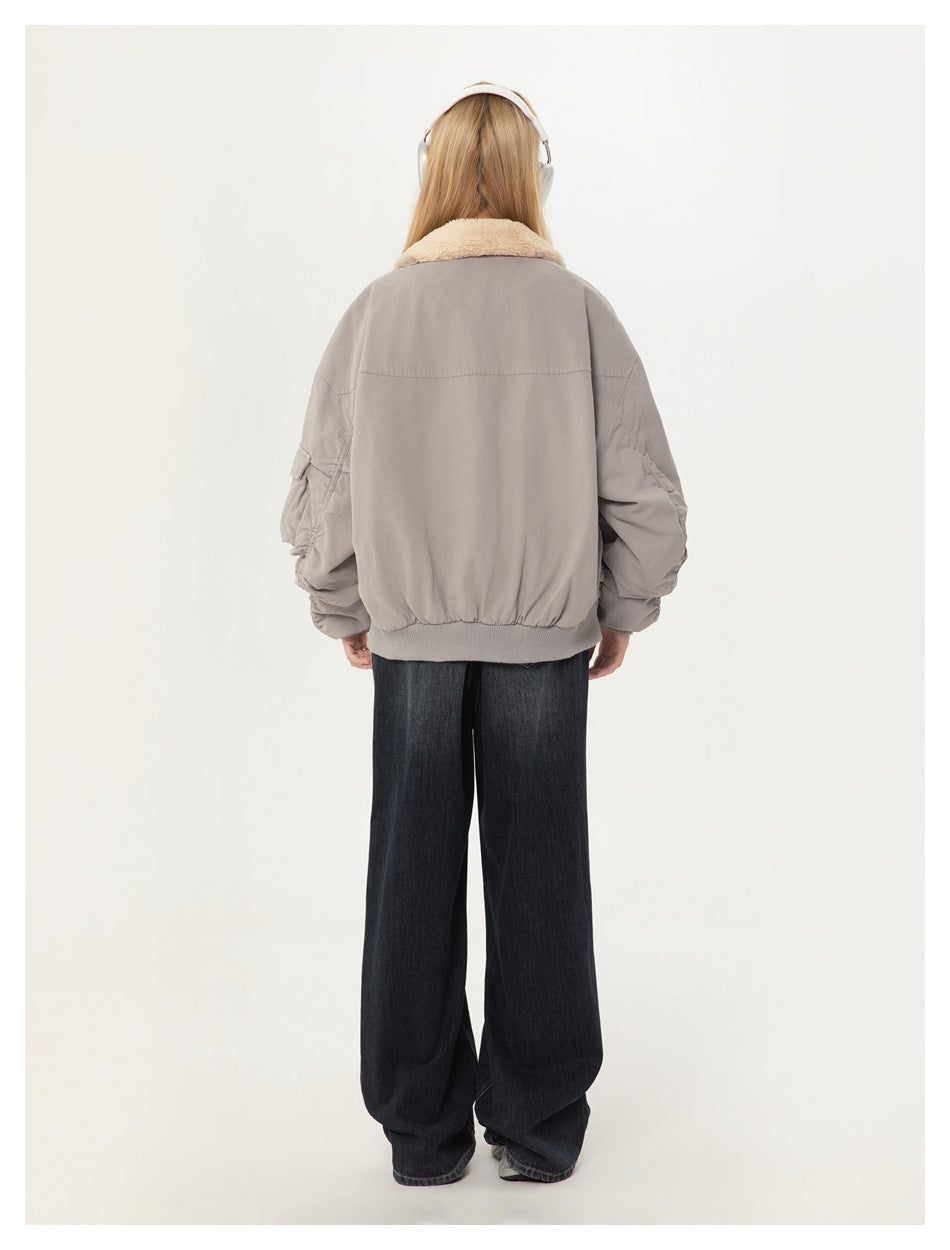Model wearing the light gray bomber jacket, showing its back and gathered sleeves.