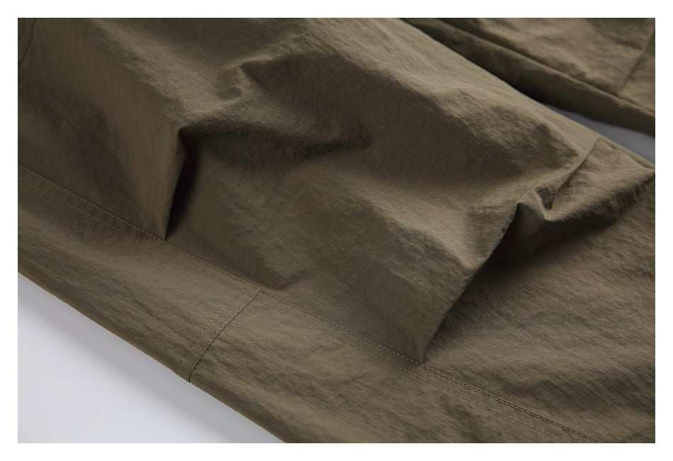Close-up showing the pants' fabric texture, panel seams, and stitching.