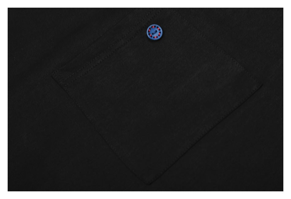 Close-up of a black shirt pocket with a small blue button accented in red.