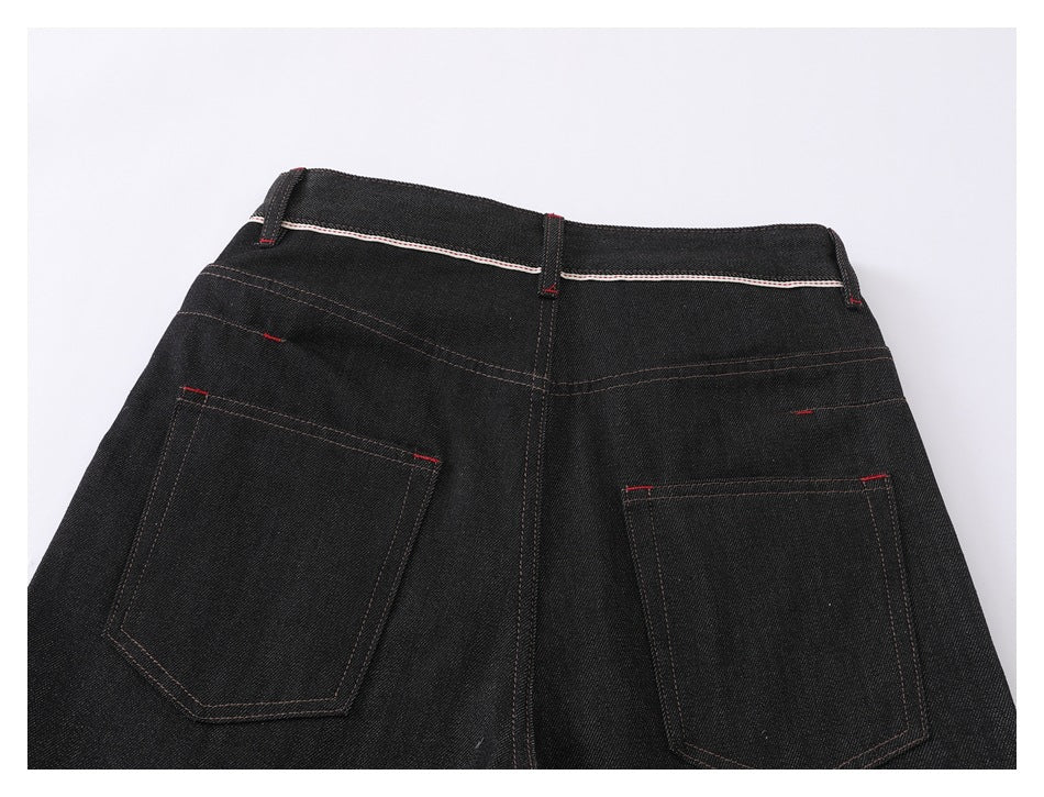 Back view of black jeans laid flat, showing two patch pockets, belt loops, and contrast stitching.