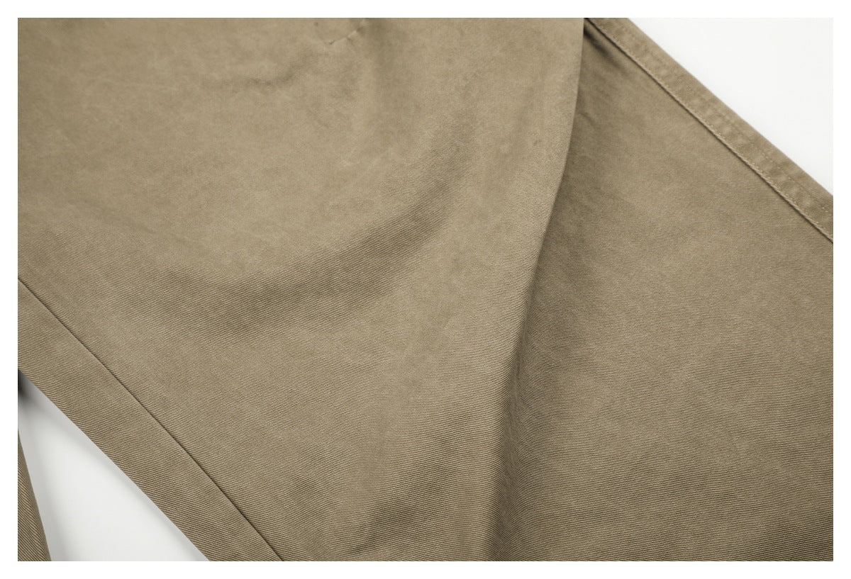 Close-up of beige pant fabric and a stitched seam.