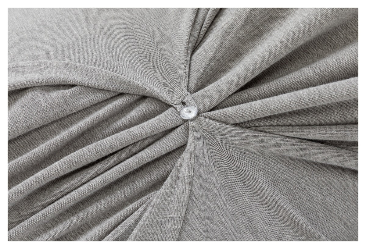 Close-up of gray fabric gathered around a small clear button.