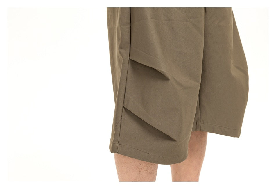 Close-up of an olive-brown shorts leg, highlighting the flap cargo pocket and stitched hem.