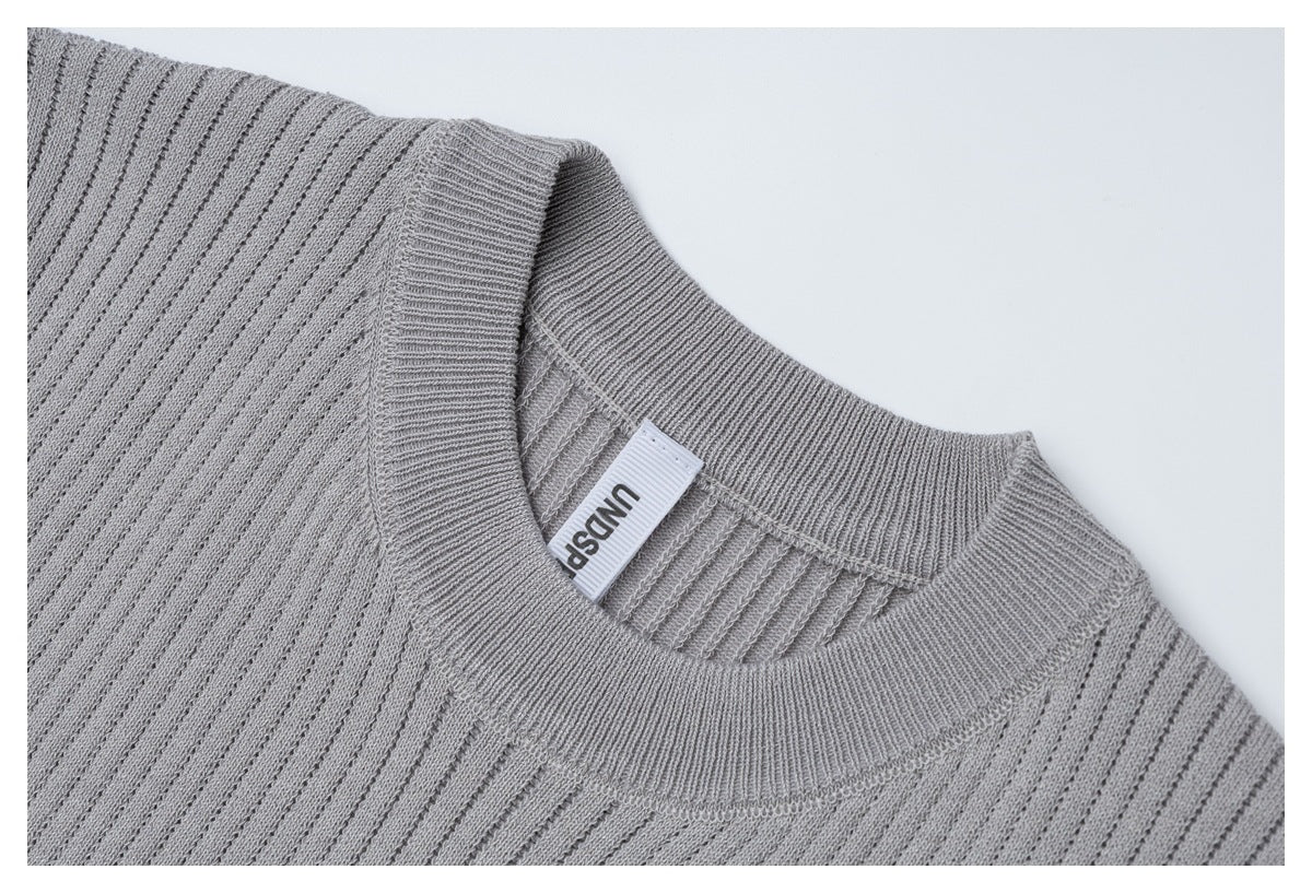 Close-up of the light gray ribbed knit top's crew neckline, shoulder stitching, and inner neck label.