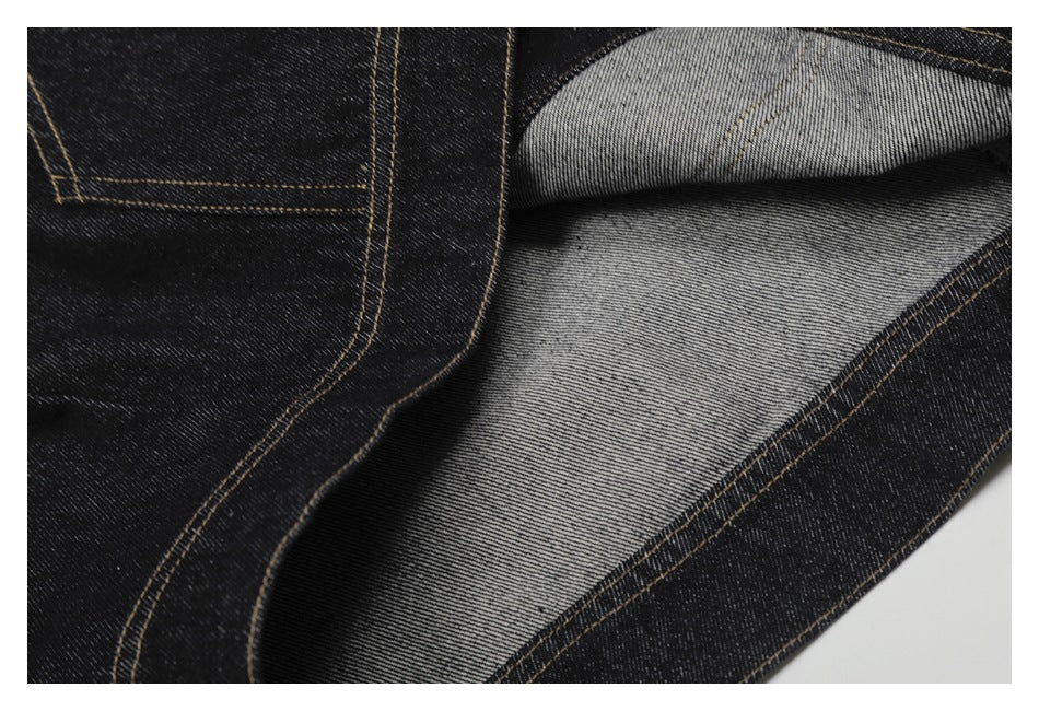 Close-up showing dark denim folded back to reveal its lighter gray reverse and stitched seams.