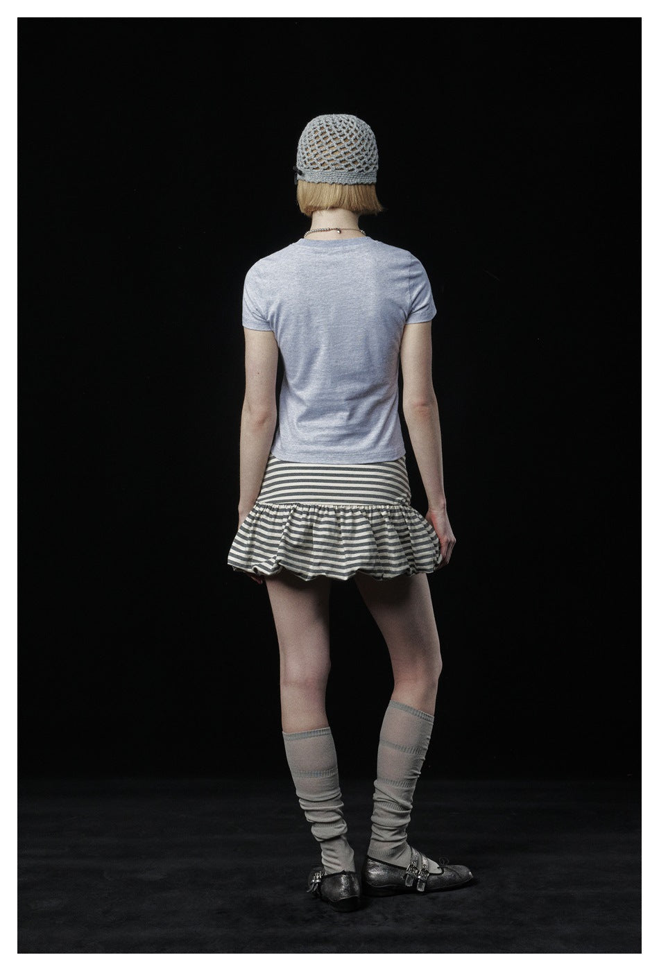 Back view of a model wearing a light gray short-sleeve T-shirt.