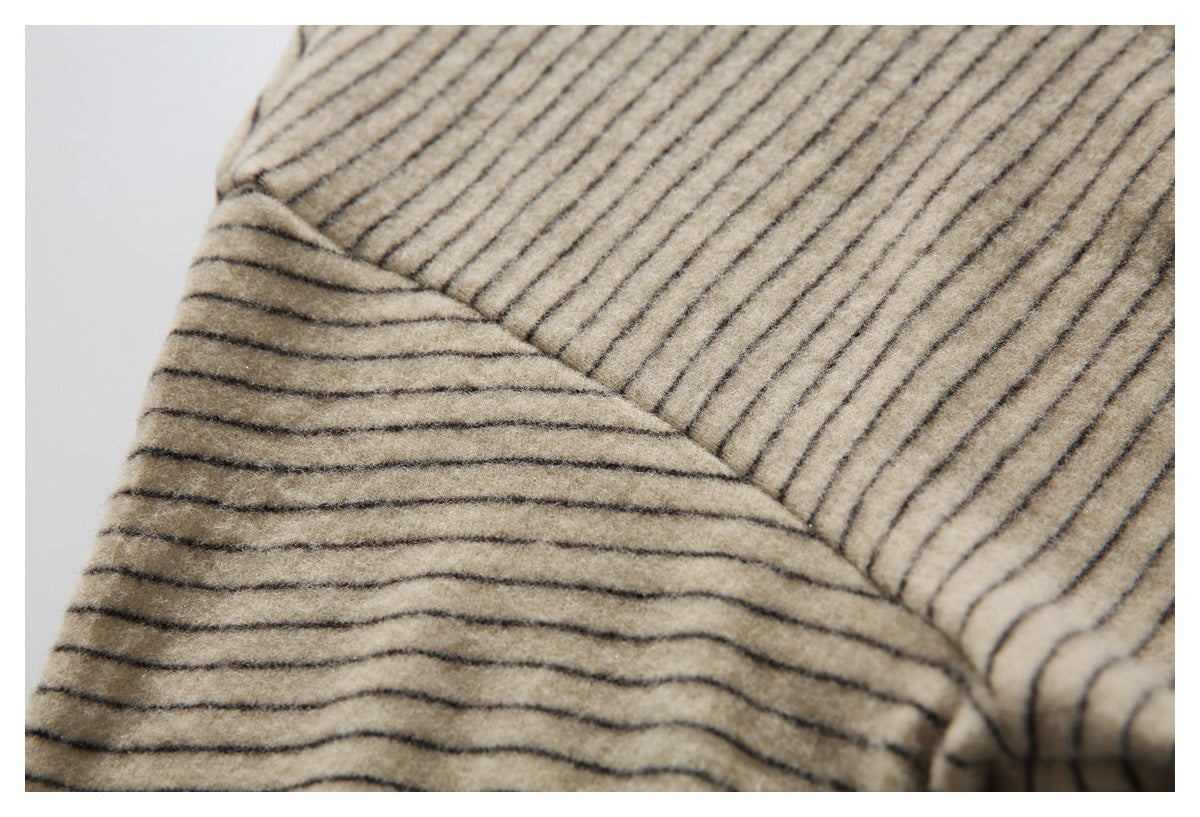 Close-up of intersecting seams and stripe alignment on beige garment fabric.