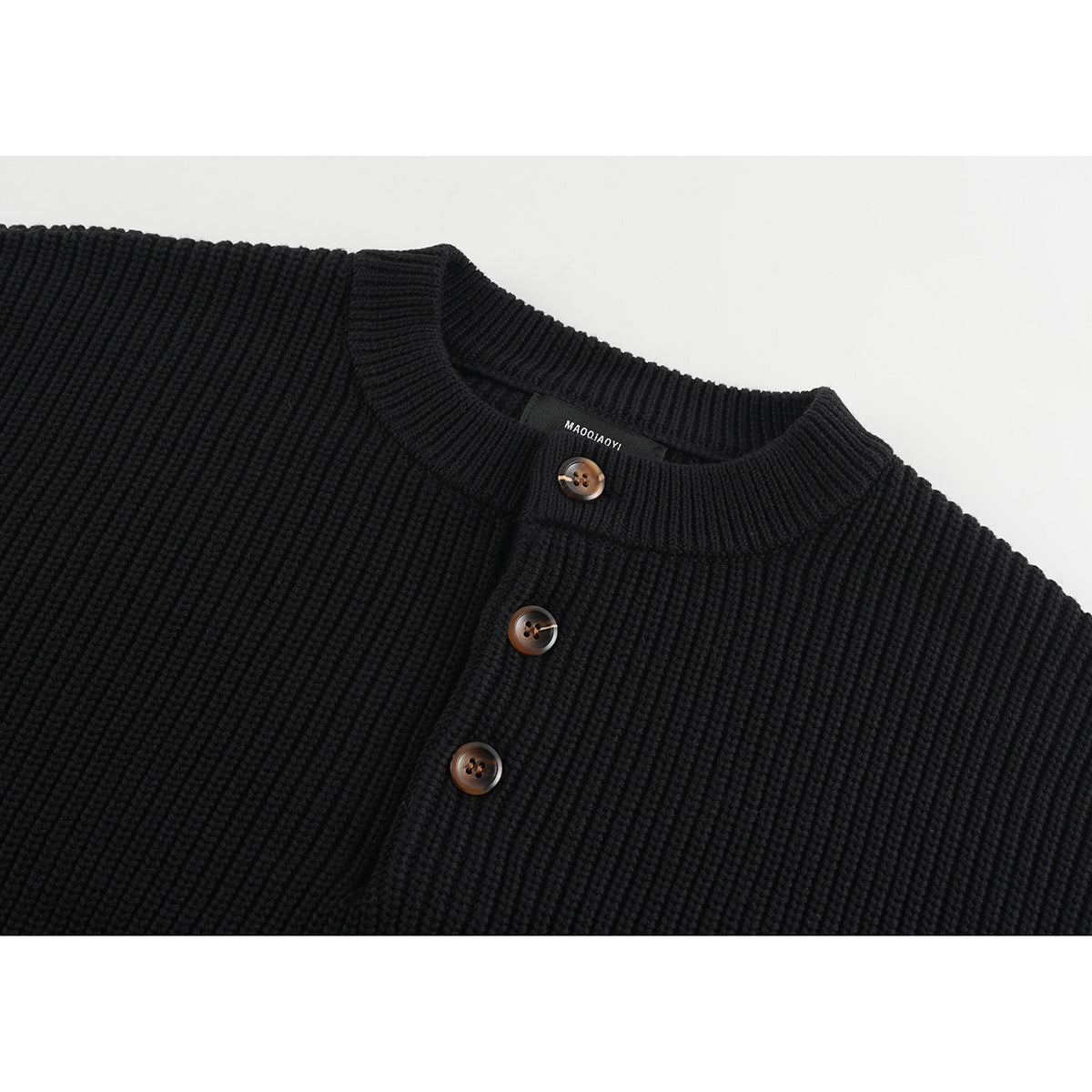 Close-up of a black rib-knit sweater's crew neckline and three brown buttons.