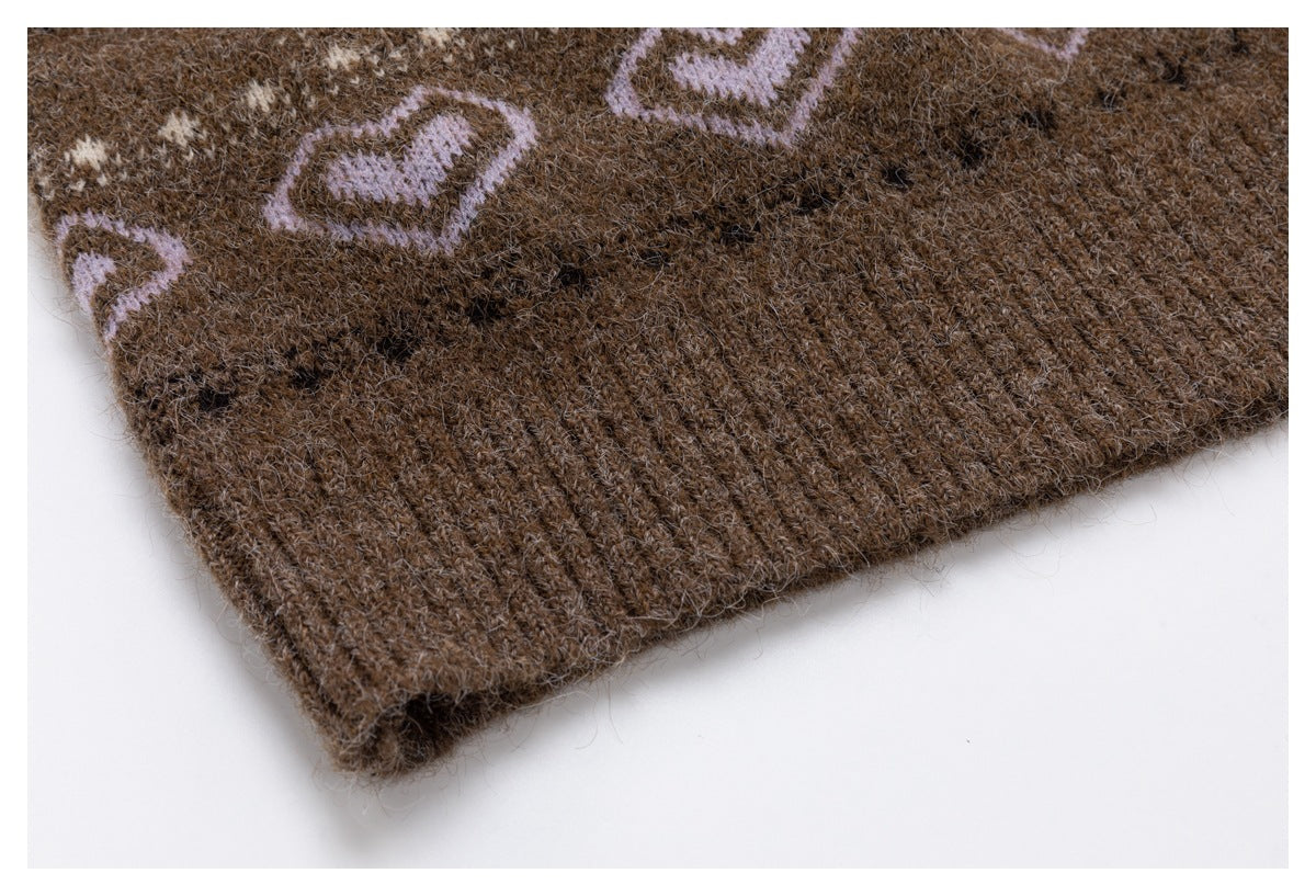 Close-up of the brown cardigan's ribbed knit hem beside part of its patterned design.