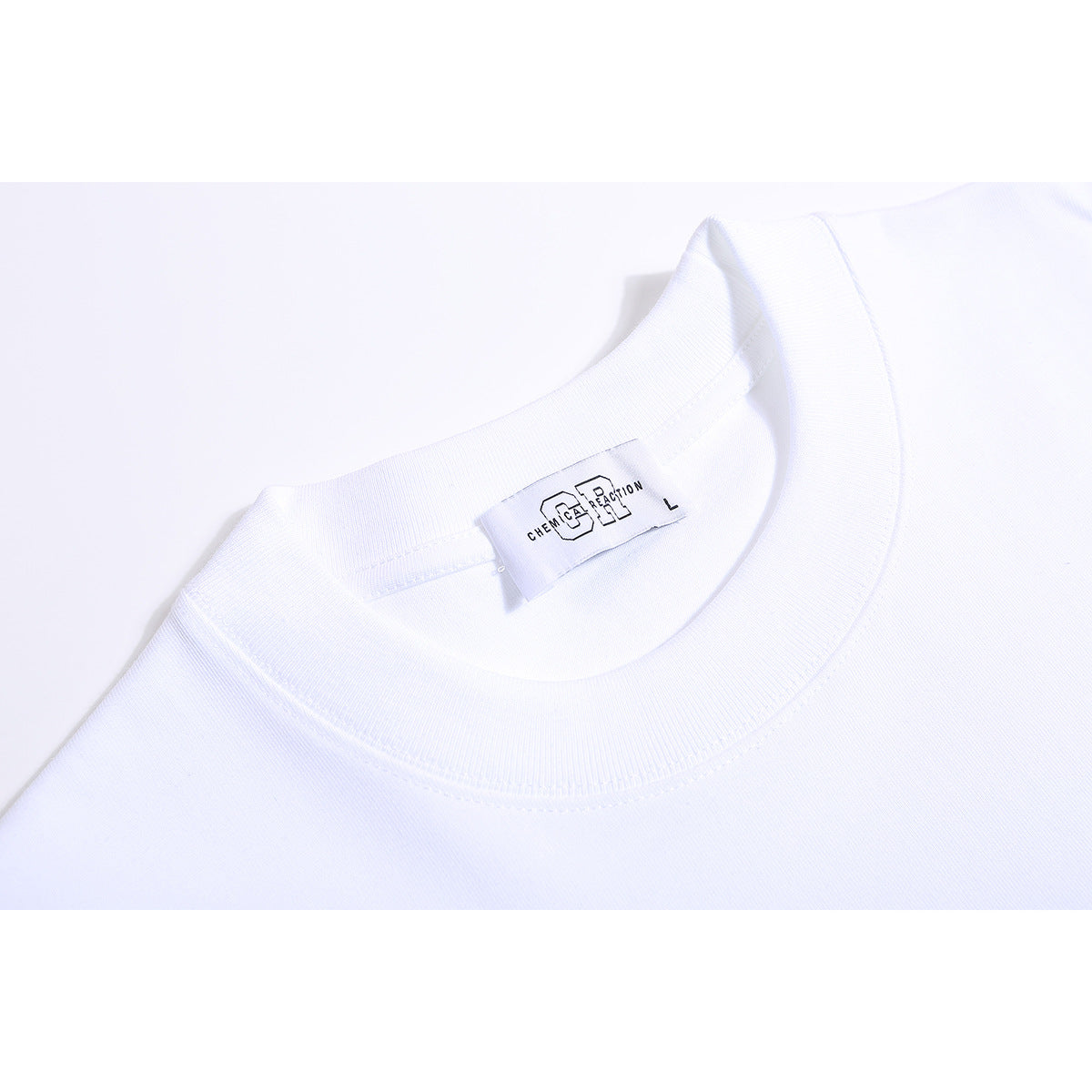 Close-up of a white T-shirt crew neckline with a sewn-in size and brand label.