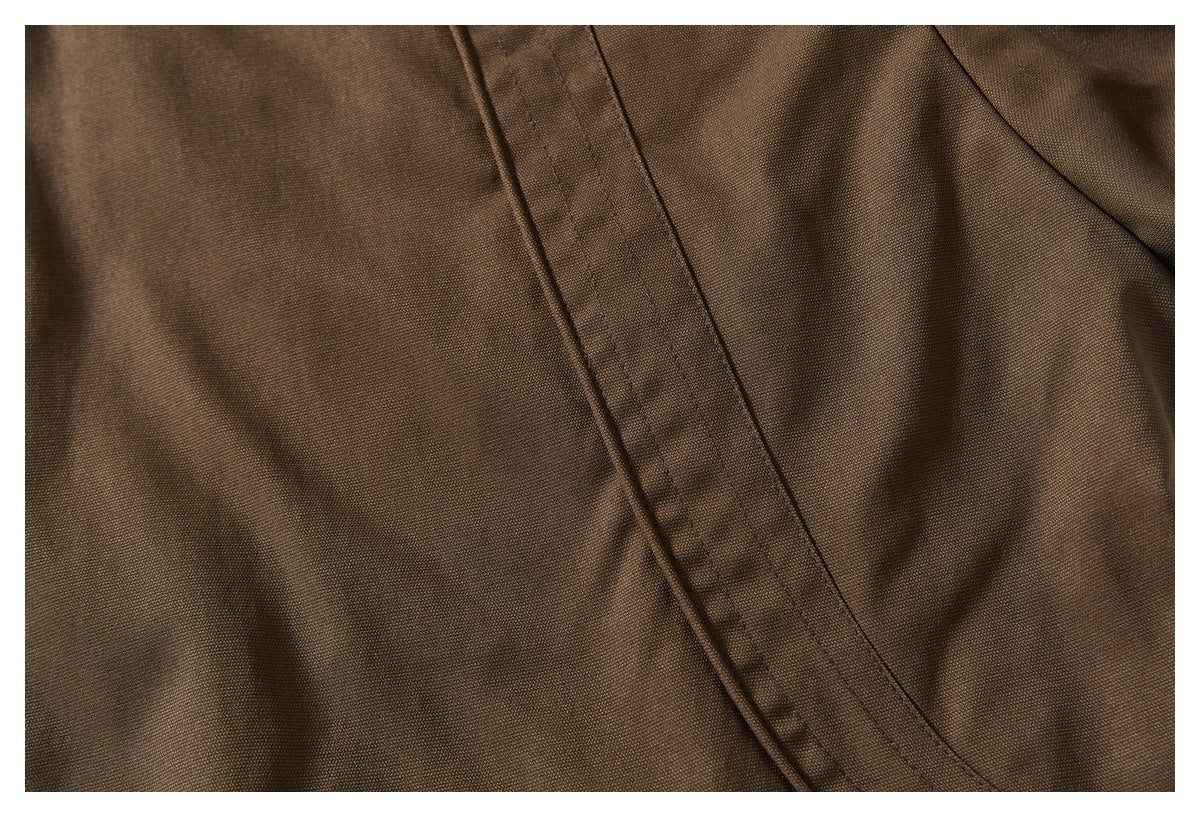 Close-up of a diagonal stitched seam across brown garment fabric.