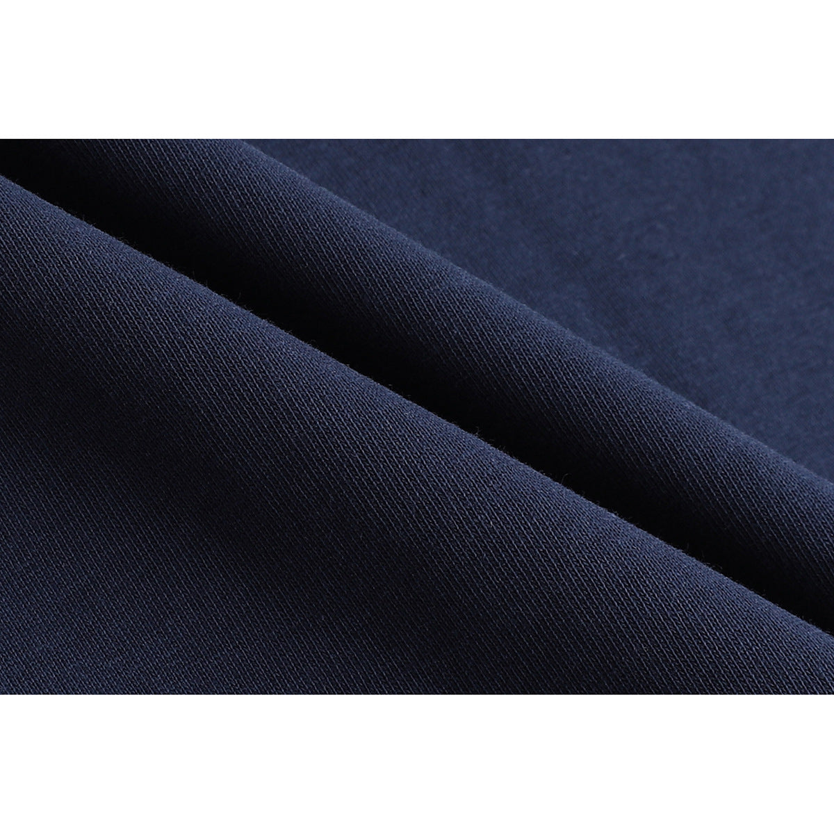 Extreme close-up of dark navy fabric folded to show its knit texture.