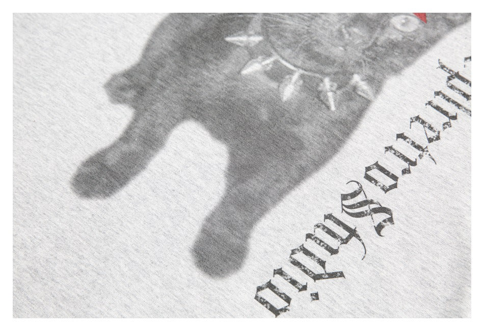 Cropped close-up of a heather-gray shirt graphic showing part of a dark animal illustration and gothic lettering.