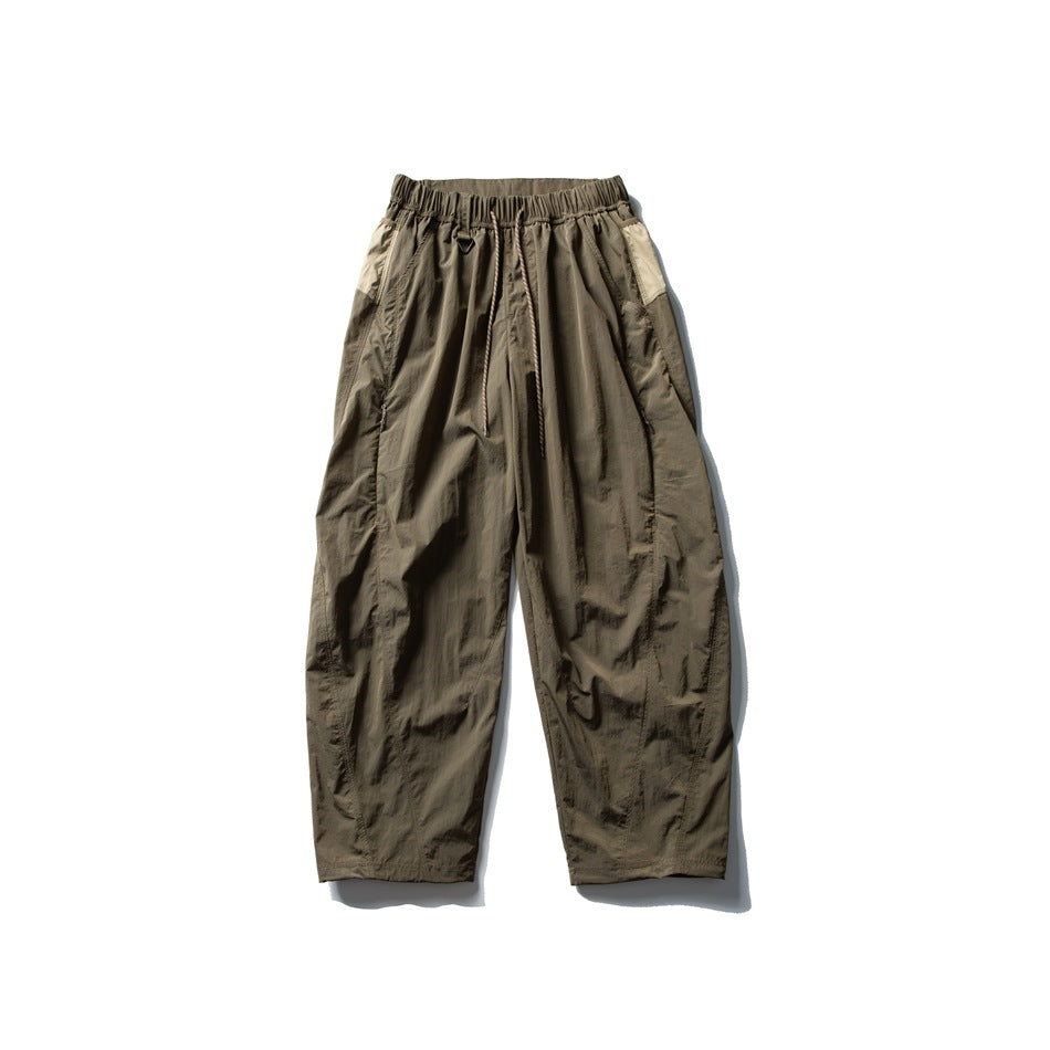 Olive-brown wide-leg drawstring pants with beige side panels, flat lay front view