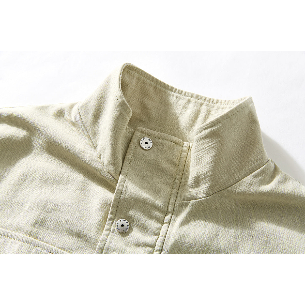 Close-up of a pale beige jacket's stand collar, front placket, and two round buttons.