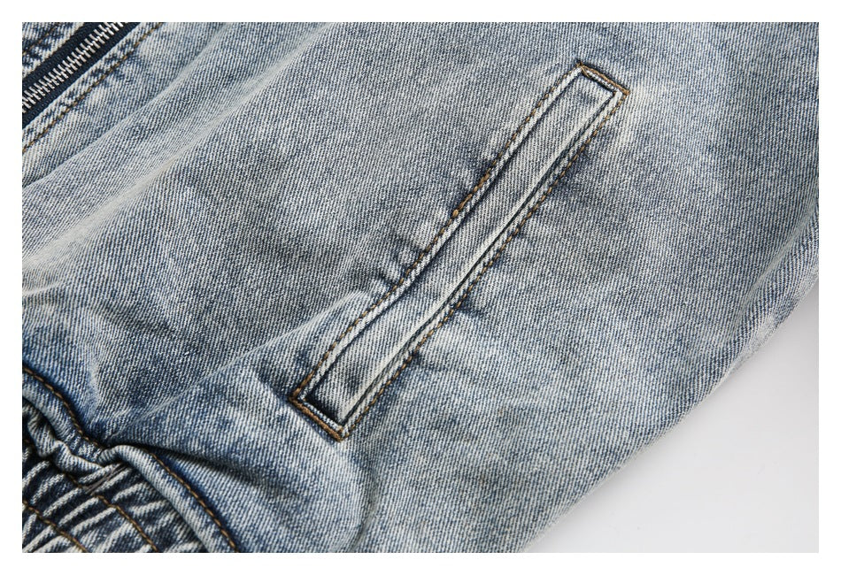 Close-up of a narrow slanted pocket opening on faded blue denim.