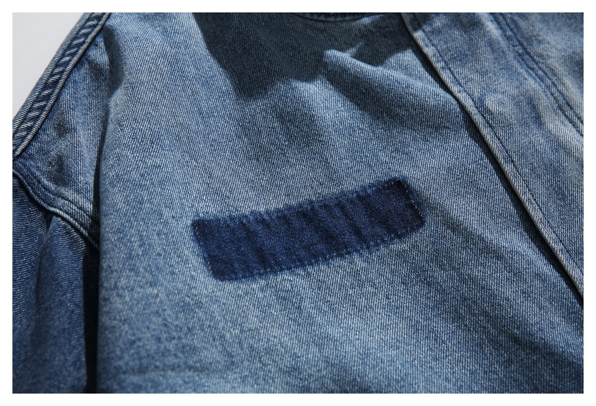 Close-up of a faded blue denim jacket interior with a dark rectangular neck label.