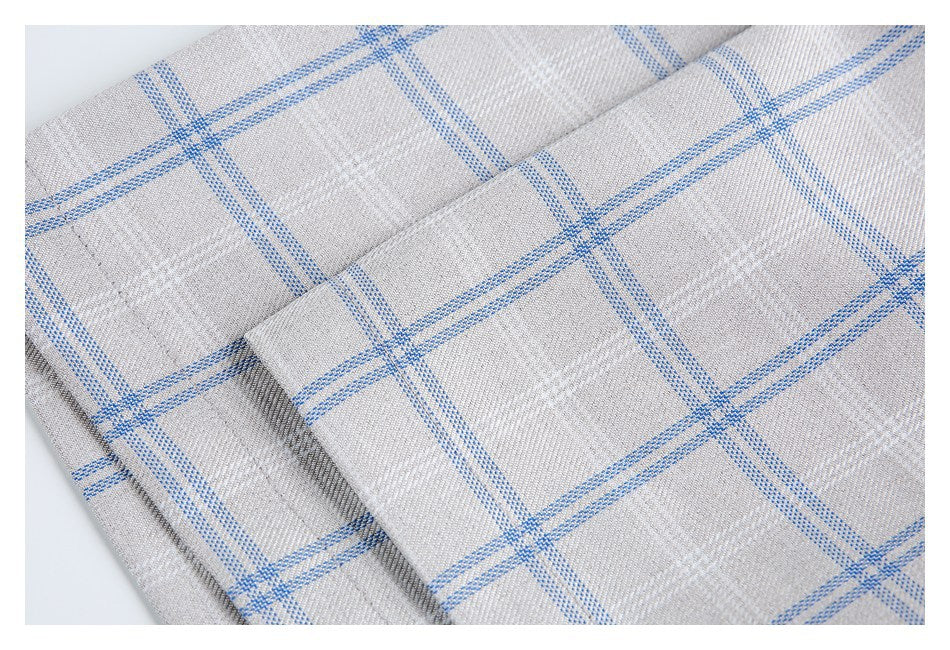 Close-up of overlapping stitched shirt fabric in a light gray and blue windowpane check.