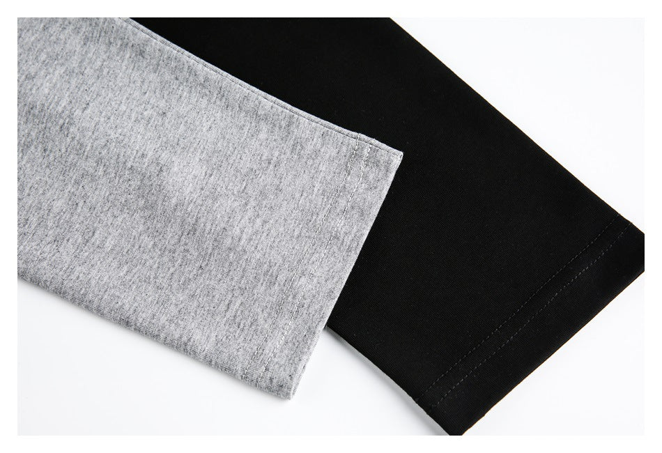 Close-up of heather gray and black long sleeves showing their stitched hems.