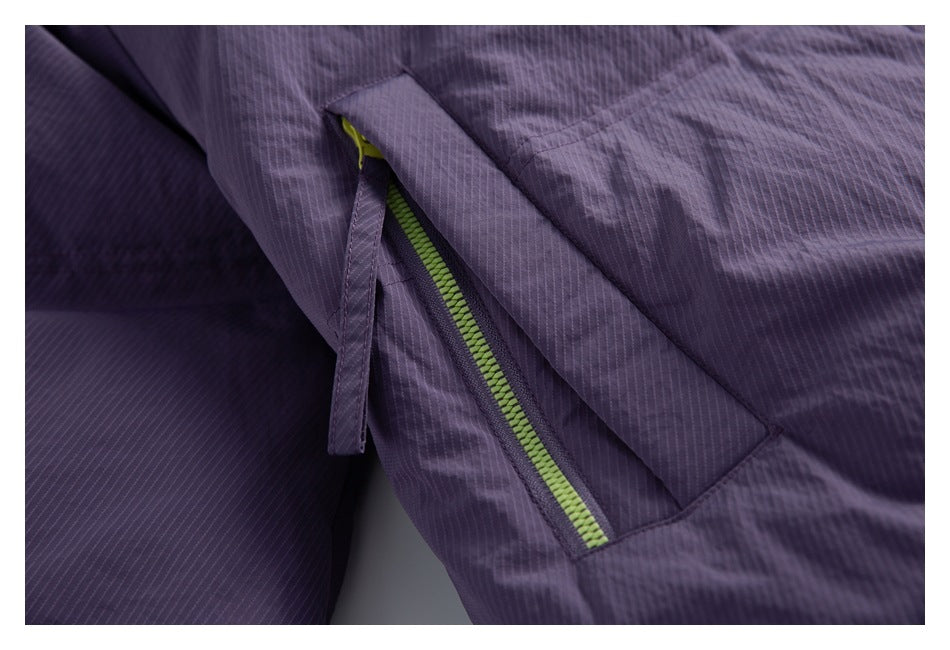 Close-up of a zippered pocket on the purple jacket, with lime-green zipper teeth and a fabric pull tab.