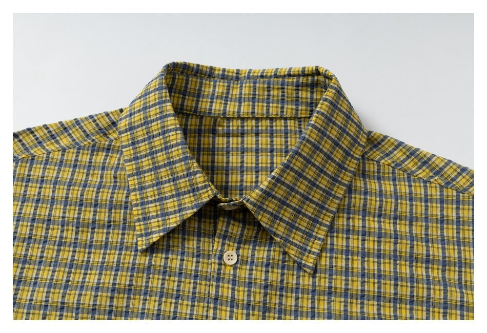 Close-up of the yellow and blue plaid shirt's pointed collar and top button.