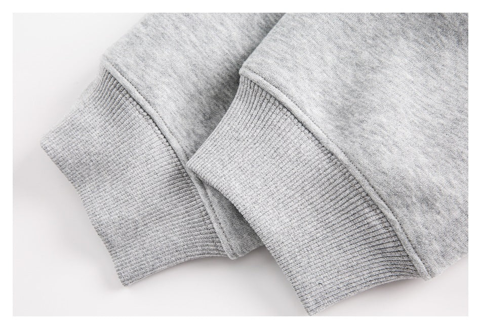 Close-up of two light gray hoodie sleeve ends with ribbed cuffs.