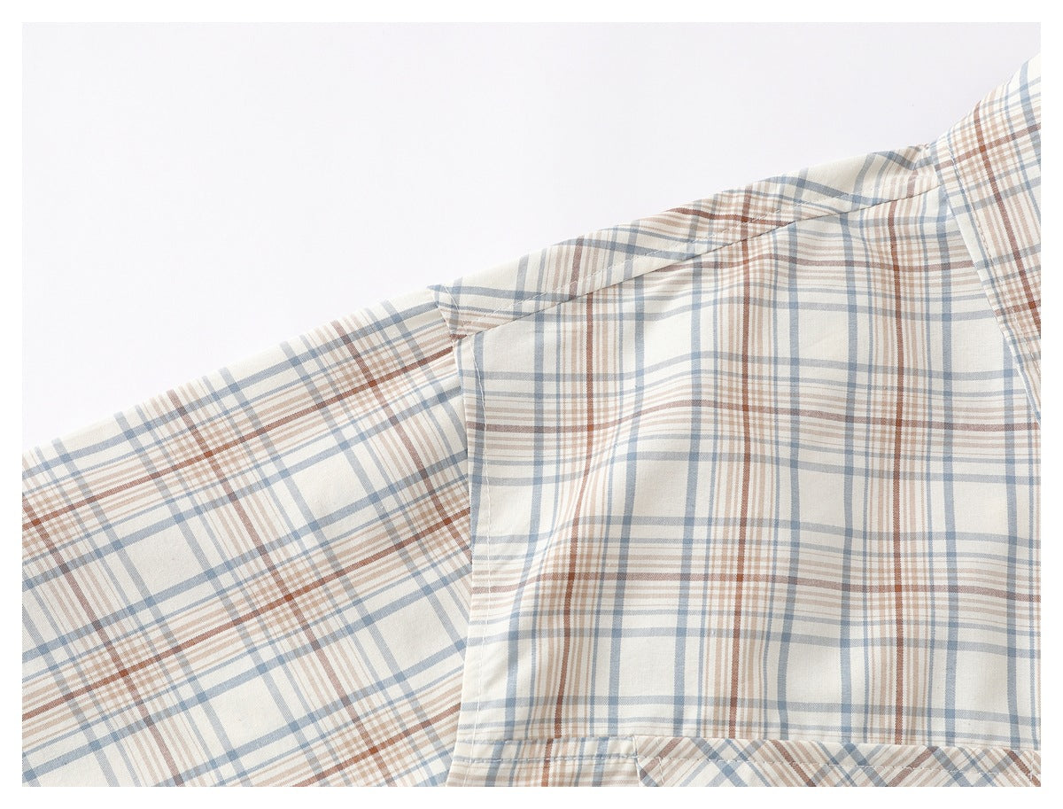 Close-up of the plaid shirt's shoulder seam and sleeve against a white background.