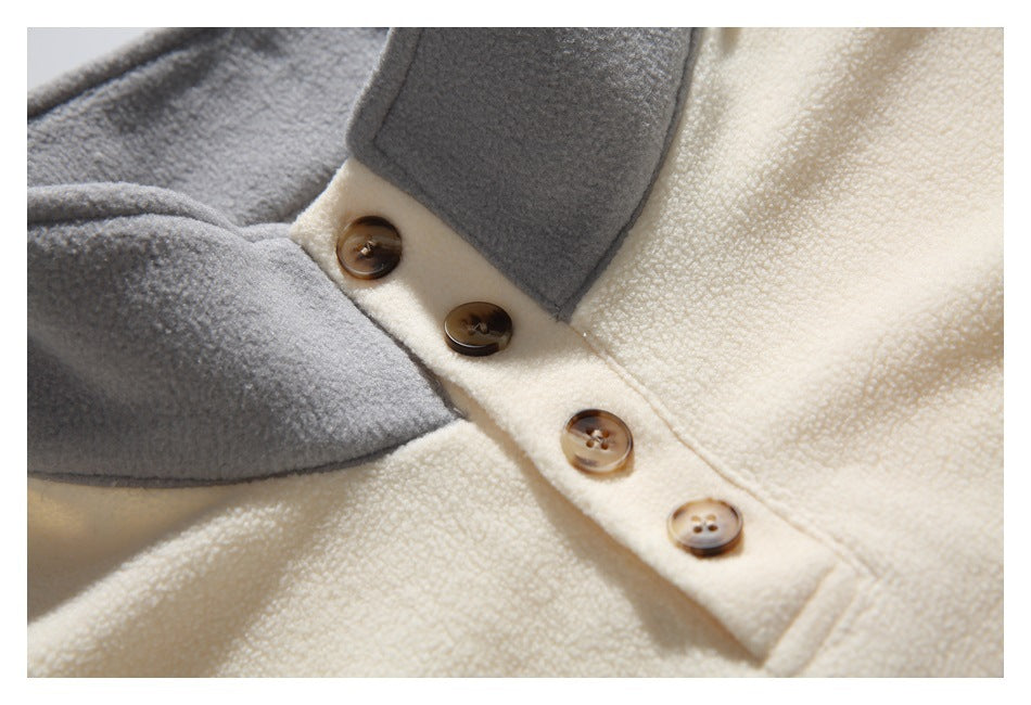 Close-up of the cream pullover's gray collar and four brown buttons on the placket.