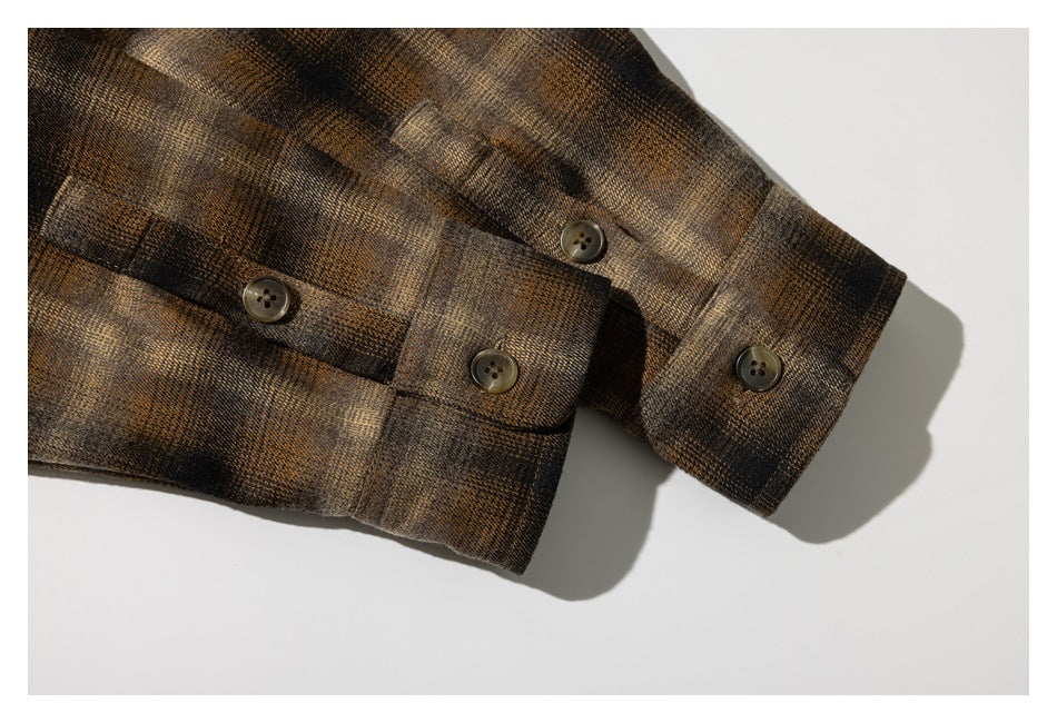 Close-up of the plaid shirt's buttoned sleeve cuffs.