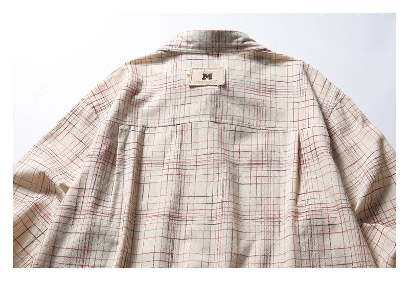 Back view of a beige plaid button-up shirt laid flat, showing its yoke, collar, and sleeves.