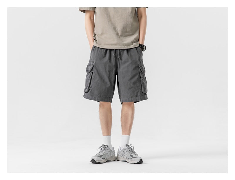 Front view of a model wearing charcoal gray cargo shorts with a drawstring waist and flap pockets.