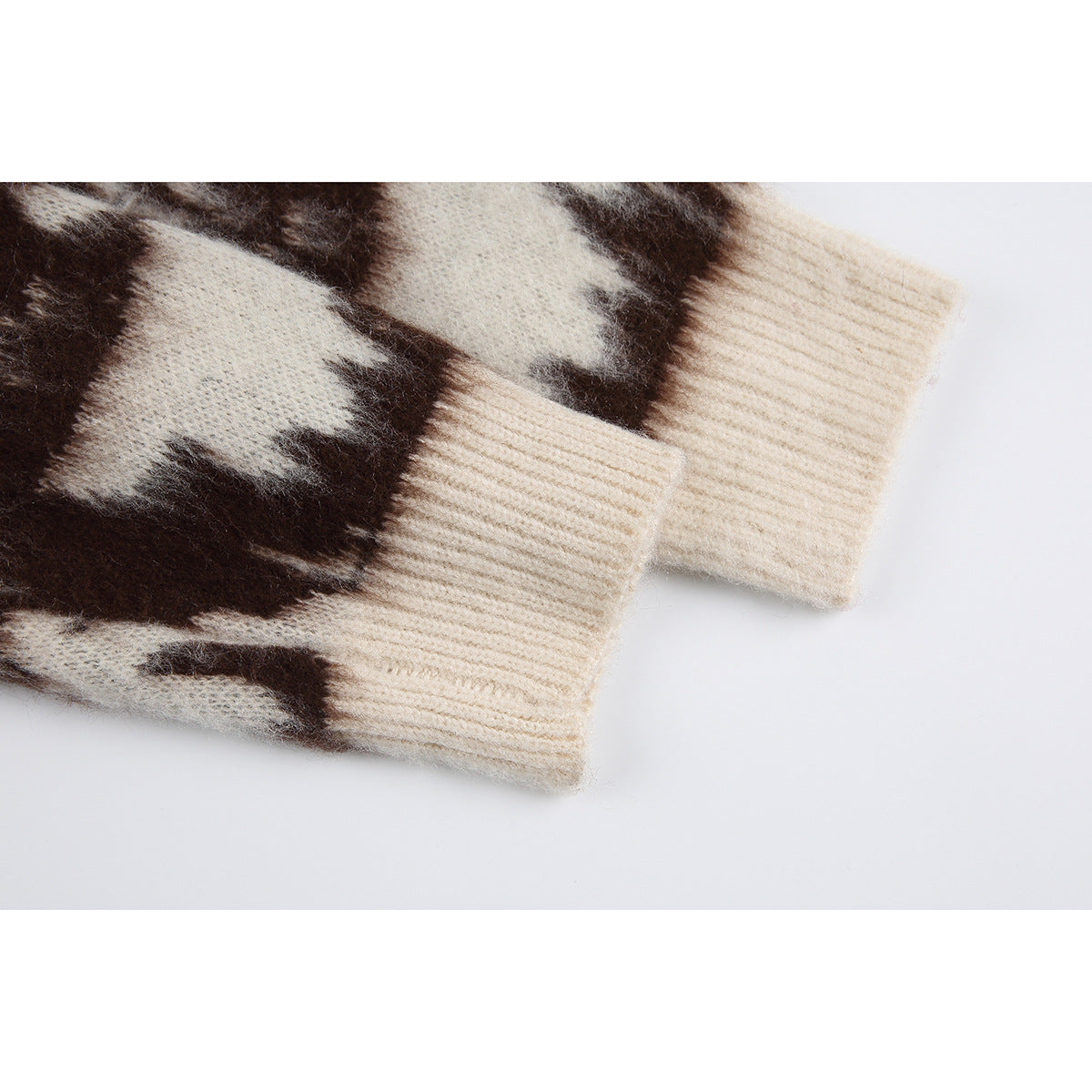 Close-up of dark brown and ivory patterned sweater sleeves with wide ivory ribbed cuffs.