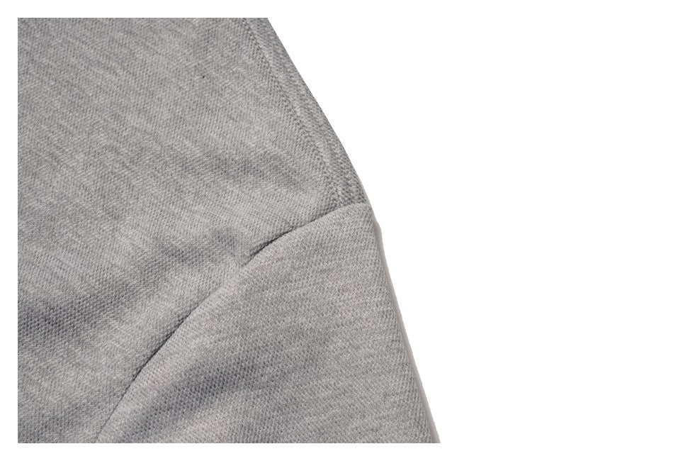Close-up of a gray sweatshirt sleeve seam and textured knit surface.