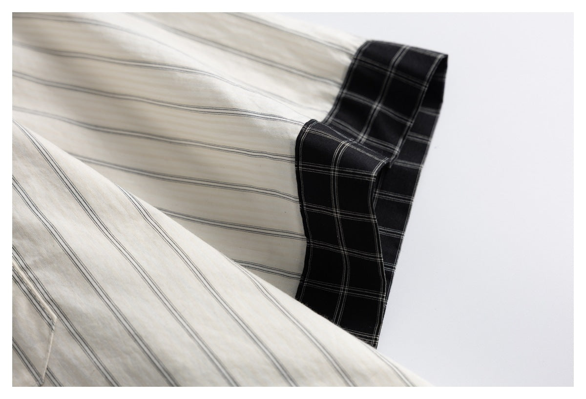 Close-up of an ivory striped shirt beside a black cuff with a fine gray plaid pattern.