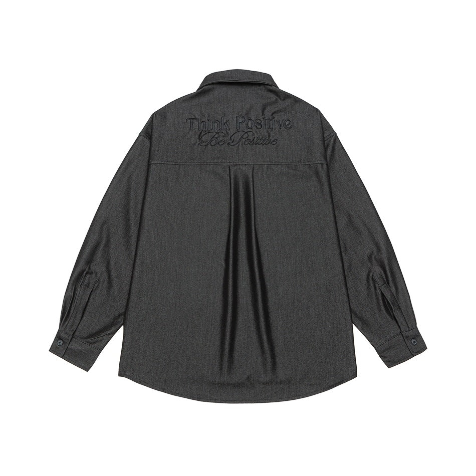 Back view of a charcoal button-up shirt with matching dark “Think Positive / Be Positive” embroidery across the shoulders.