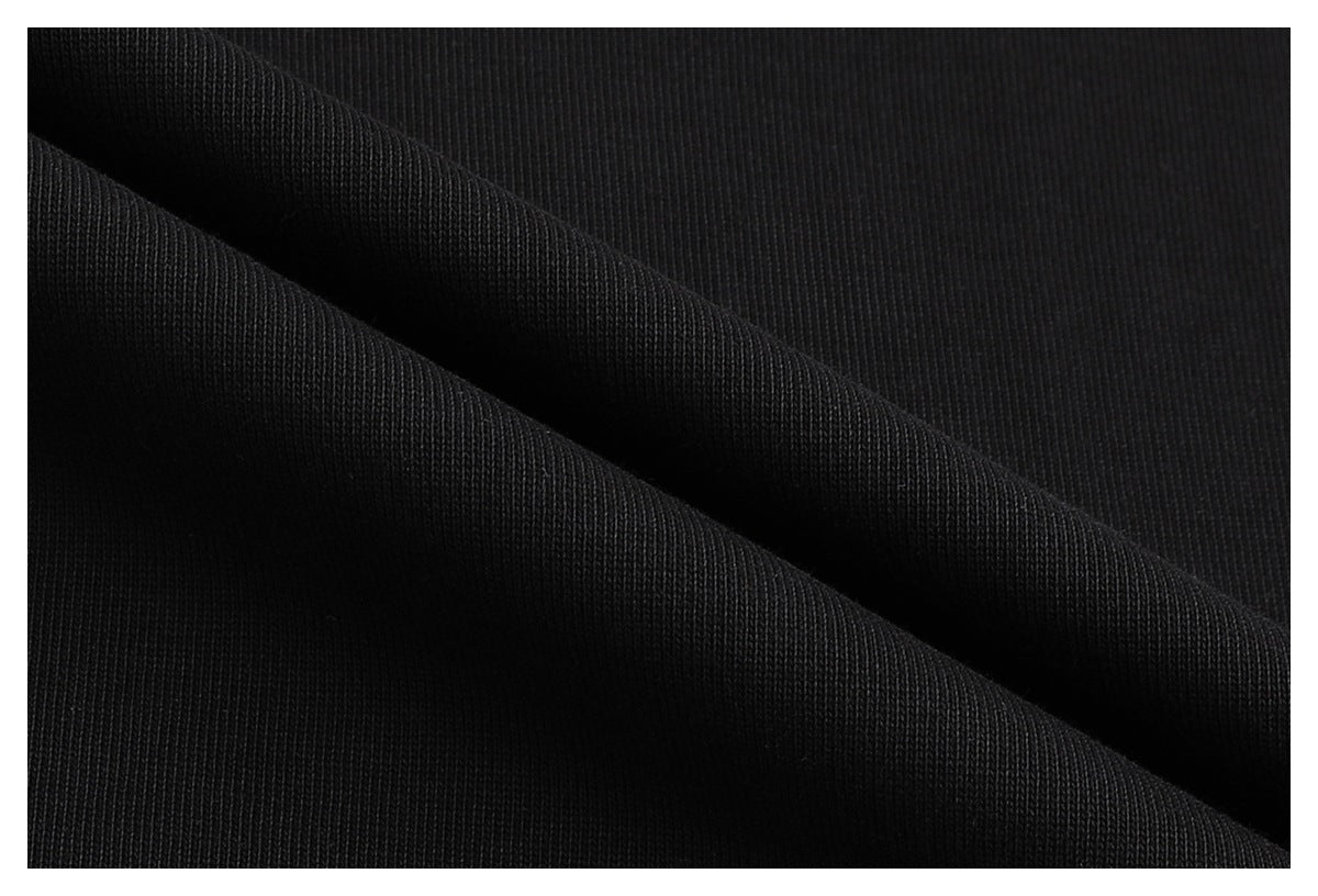 Close-up of black knit fabric folded to show its surface texture.