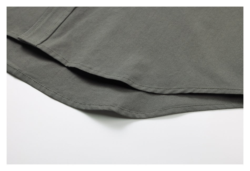 Close-up of the dark gray shirt's curved hem and double-stitched edge.