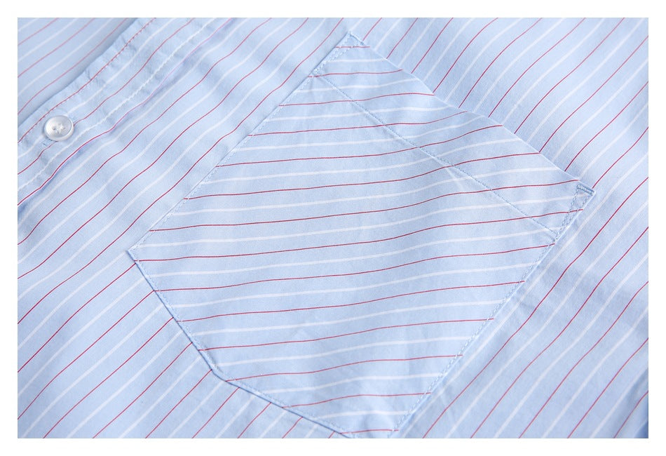 Close-up of a light blue shirt pocket with red and white stripes and a white button.