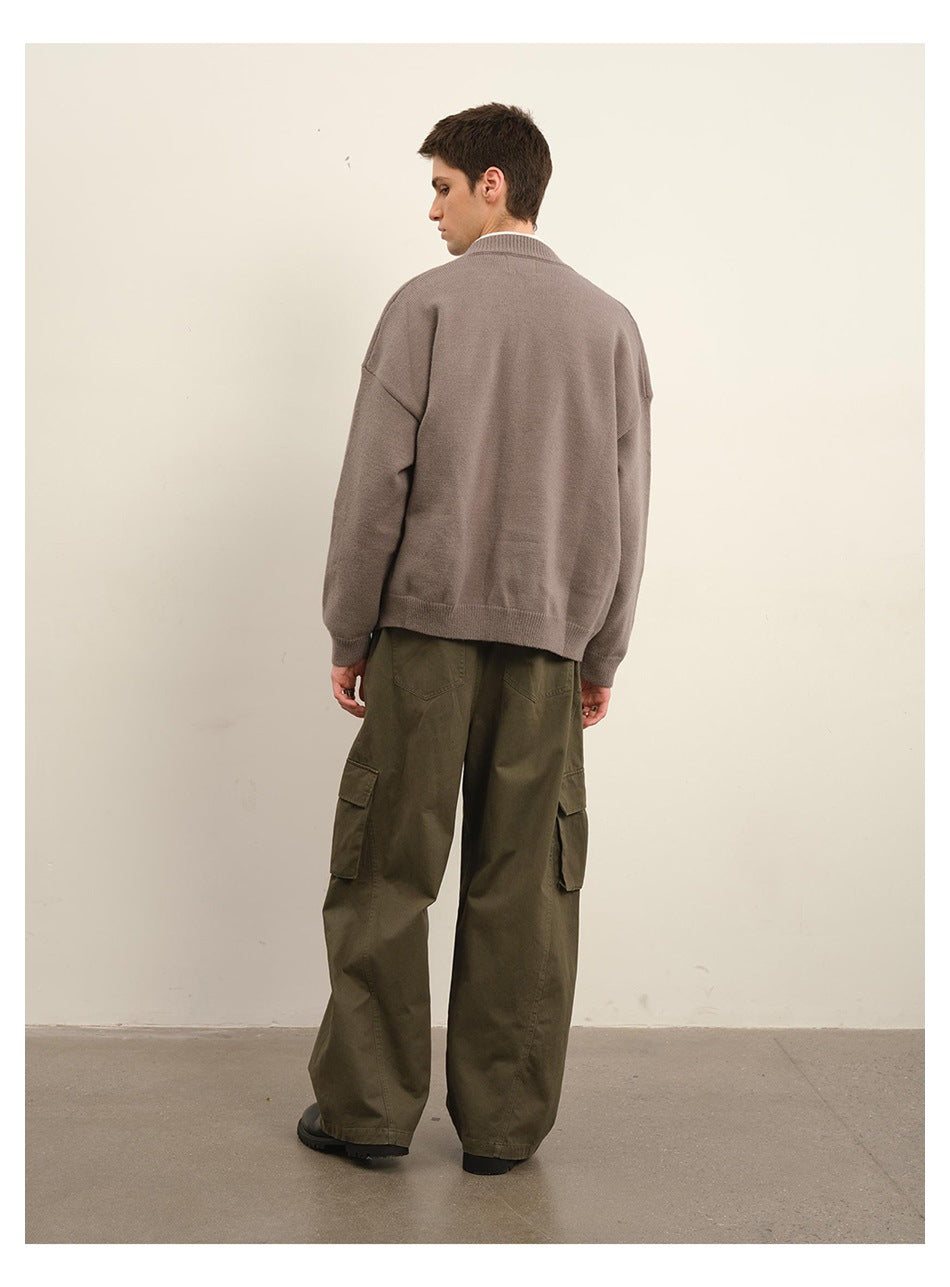 Back view of a model wearing a taupe button-front cardigan with olive cargo pants.