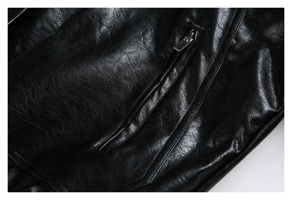 Close-up of a slanted zip pocket on the black leather-look jacket.