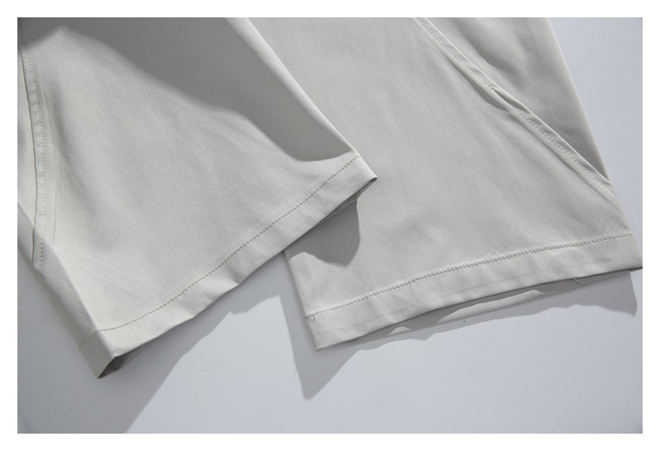 Close-up of light gray shorts hems with neat stitching and overlapping fabric.