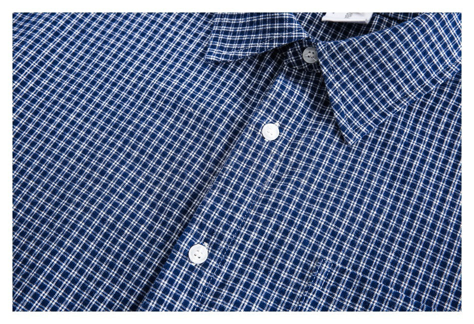 Close-up of the blue-and-white checked shirt front, collar, white buttons, and chest pocket.