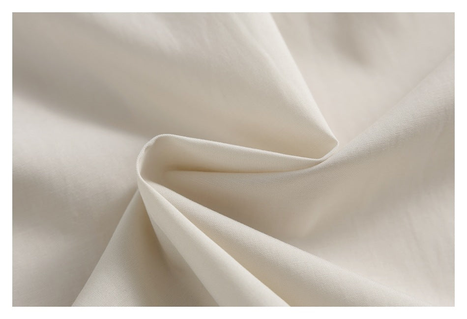 Close-up of ivory fabric folded into soft, sculptural folds.