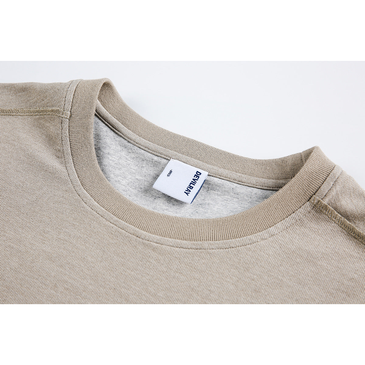 Close-up of a beige crew neckline with ribbed trim and an interior DEVILRAY label.