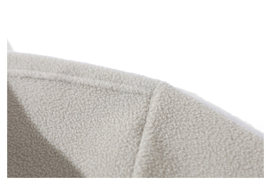 Close-up of a seam across the cream sherpa jacket fabric.