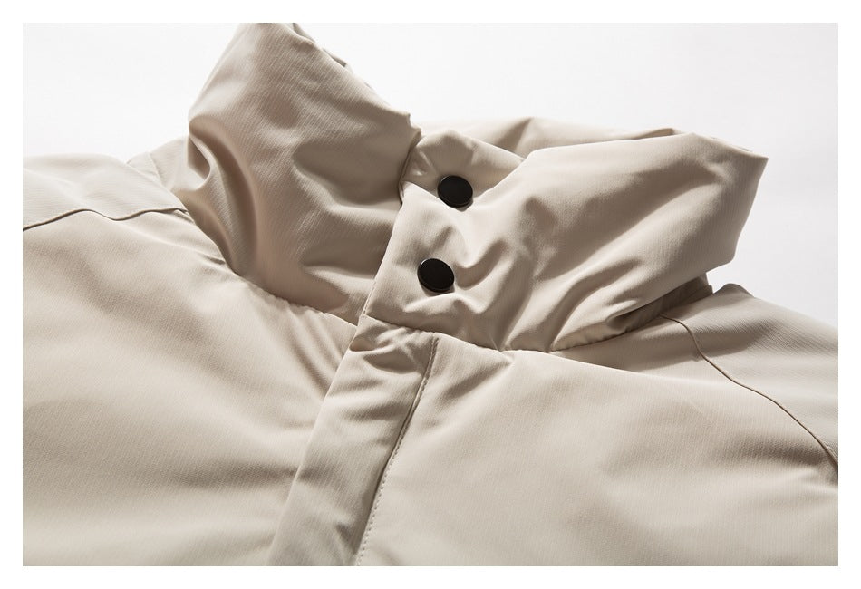 Close-up of a beige jacket hood and front placket with two black snap buttons.