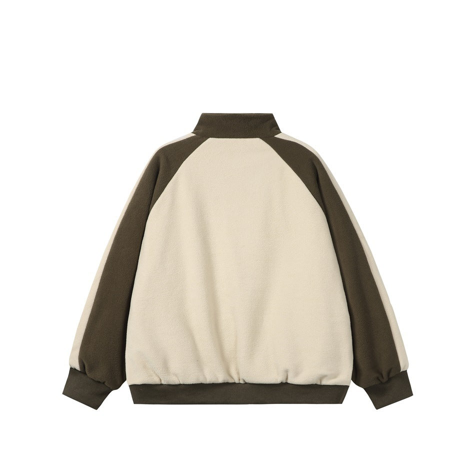 Back of a cream jacket with dark olive raglan sleeves, a stand collar, and matching ribbed cuffs and hem.