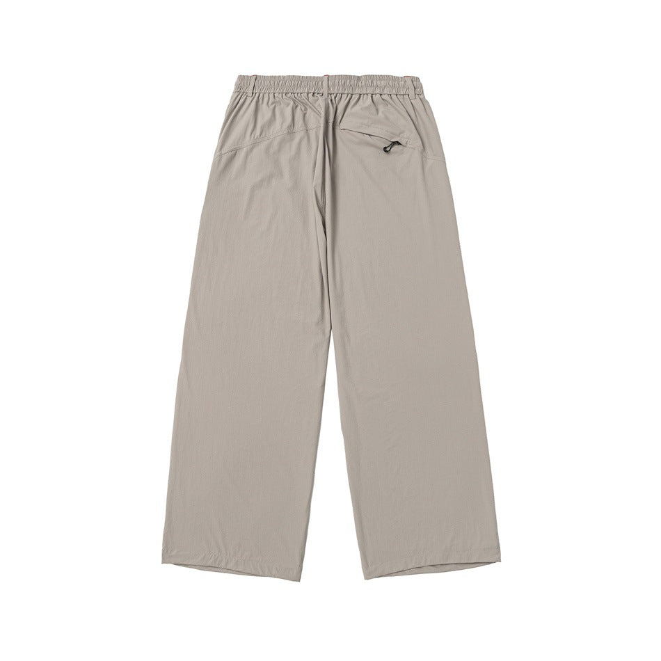 Back view of beige khaki wide-leg pants with elastic waistband, yoke seams and a zip back pocket