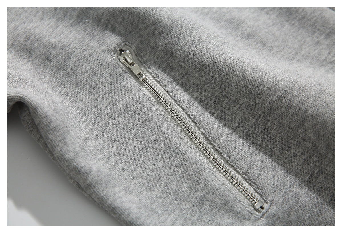 Close-up of a silver zipper on heather gray knit fabric.